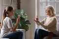 Grown up daughter talk with elderly mother using sign language