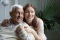 Grown up loving granddaughter hugging elderly 75s grandfather