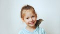 Grown up starling nestling sit on shoulder of little girl and sing with open beak. Portrait of happy child on gray.