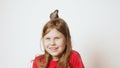 Grown up starling nestling sitting on head of glad little girl. Portrait of happy child on white. Nest on human head.