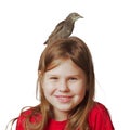 Grown up starling nestling sitting on head of joyful little girl. Portrait of smiling child isolated on white.