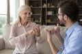 Grownup son communicates with senior mother using gestures