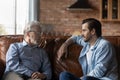 Grownup son talk with elderly father at home