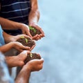 Growth lies in each of our hands. Closeup shot of a group of people holding plants growing in soil. Royalty Free Stock Photo