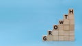 Growth. word GROWTH written on wooden cube block stack on blue background Royalty Free Stock Photo