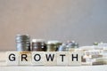 Growth Word Written In Wooden Cube on wood table with money stack up as graphs in background Royalty Free Stock Photo