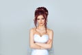 Grumpy bride. Sad and disappointed hesitating woman in wedding dress, arms folded, unhappy wife