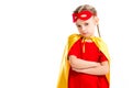 Grumpy little supergirl wearing yellow cape with red mask for eyes on forehead