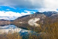 Grundlsee with mountain range and cloudy sky. Bushes in the foreground. Royalty Free Stock Photo