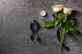 Black mourning ribbon, flowers and candle on grunge background Royalty Free Stock Photo