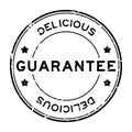 Grunge black guarantee delicious word round rubber stamp on white background