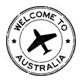 Grunge black welcome to Australia word with airplane icon round rubber stamp on white background