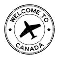 Grunge black welcome to Canada word with airplane icon round rubber stamp on white background