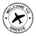 Grunge black welcome to Greece word with airplane icon round rubber stamp on white background