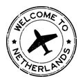 Grunge black welcome to Netherland word with airplane icon round rubber stamp on white background