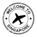 Grunge black welcome to Singapore word with airplane icon round rubber stamp on white background