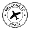 Grunge black welcome to Spain word with airplane icon round rubber stamp on white background