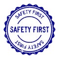 Grunge blue safety first word round rubber stamp on white background