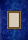 Grunge blue stucco wall with empty picture frame