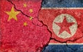 Grunge country flag illustration cracked concrete background / China vs North korea Political or economic conflict