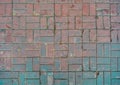 Grunge cracked red street tiles, blue paint. City street pavement cobblestone