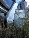 Grunge dirty retro gray milk can with a wooden handle, stands in Royalty Free Stock Photo