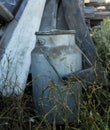 Grunge dirty retro gray milk can with a wooden handle, stands in Royalty Free Stock Photo