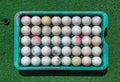 Grunge golf balls in tray on green Royalty Free Stock Photo