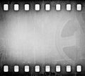 Grunge gray scratched dirty film strip with movie reel background. Royalty Free Stock Photo