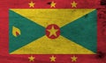 Grunge Grenadian flag texture, red border with six Gold star, Gold and green triangles with red disk.
