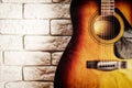 Grunge image of the old acoustic guitar in the interior with white brick wall Royalty Free Stock Photo