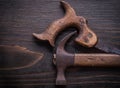 Grunge longstanding handsaw and claw hammer on vintage wooden bo