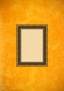 Grunge orange stucco wall with empty picture frame Royalty Free Stock Photo