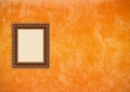 Grunge orange stucco wall with empty picture frame Royalty Free Stock Photo