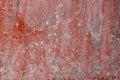 Grunge painted wall in dark red flake with crack texture of stains and scale. Royalty Free Stock Photo