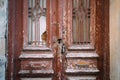 Grunge peeled wood texture door, rusty padlock. Old cracked iron metal rusty window bar, broken glass. Royalty Free Stock Photo