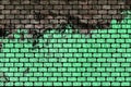 Grunge ruined semi painted pastel green bricks wall with dark black