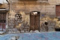 Grunge stone bricks wall with Broken wooden door and closed broken window in abandoned district Royalty Free Stock Photo