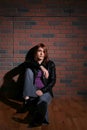 Grunge teen lounging in front of brick wall