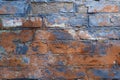 Grunge texture brick wall background. Close-up of old cracked blue red paint on brickwork, exterior of rough wall outdoors Royalty Free Stock Photo