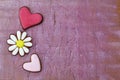 Grunge two hearts and daisy flower vintage background. Gingerbread cookies on a vintage wooden lilac background. Concept of love Royalty Free Stock Photo