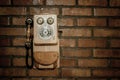 Grunge urban background of a brick wall with an old out of service payphone Royalty Free Stock Photo