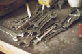 Grunge, vintage wooden workbench with rustic old metal wrenches of different measures lying. Old toolbox background. View from top Royalty Free Stock Photo