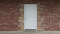 Grunge white door in brick and stone wall