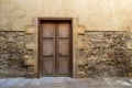 Grunge wooden aged door on grunge stone bricks wall