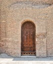 Grunge wooden aged vaulted door on stone bricks wall Royalty Free Stock Photo