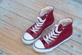 Grunge wooden background with red and white used vintage canvas sneakers