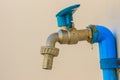 Grungy bronze field faucet connected with blue PVC pipe in white Royalty Free Stock Photo