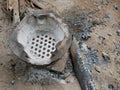 A grungy charcoal stove / grill at home in a rural area of Thailand with wooden sticks placed next to ready to be used