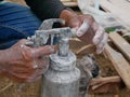 A grungy dirty paint sprayer in hands of a painter about to be opened and refilled to get it ready for the next round of spraying